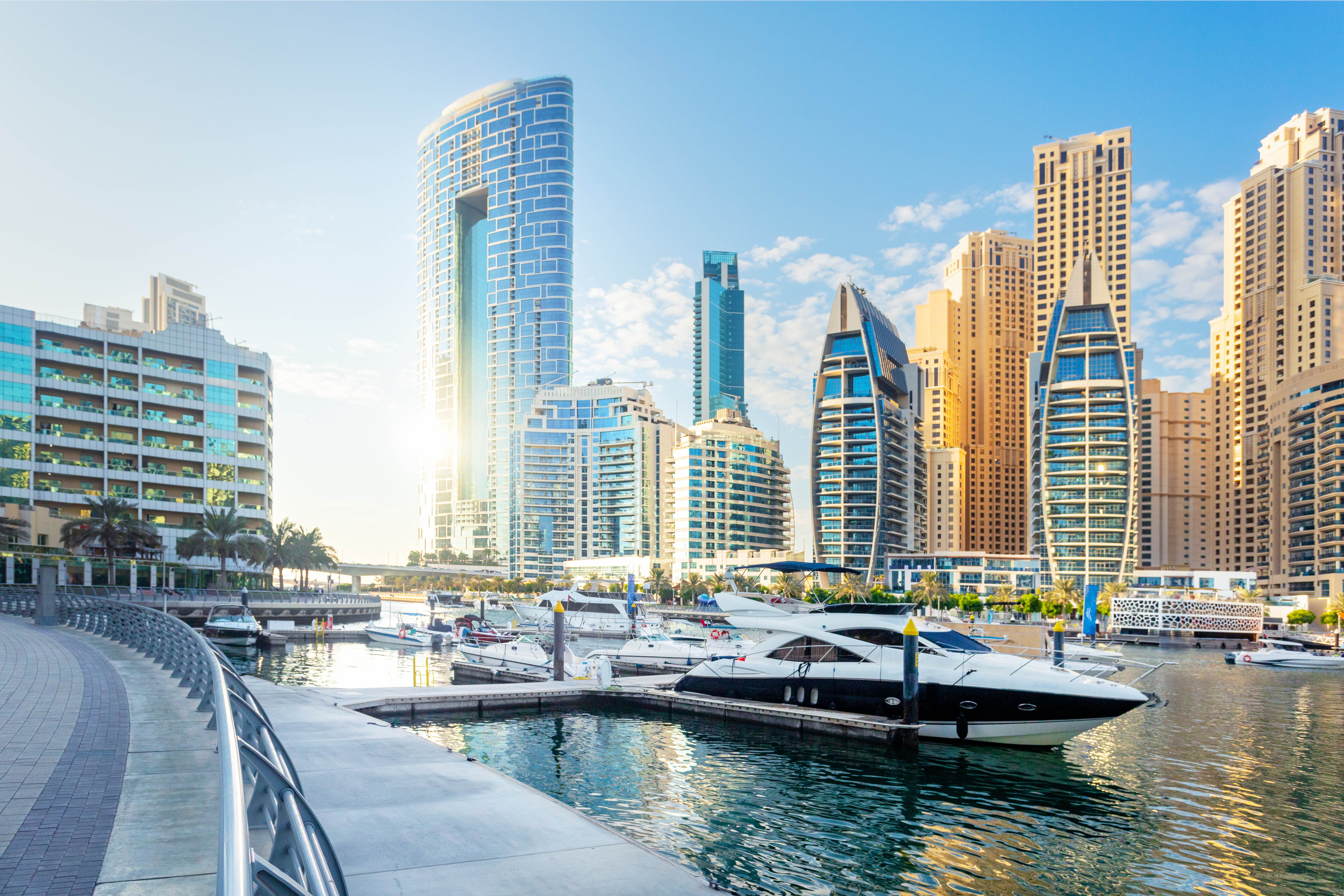 Dubai Marina with high rise buildings in the background and boats in the foreground.