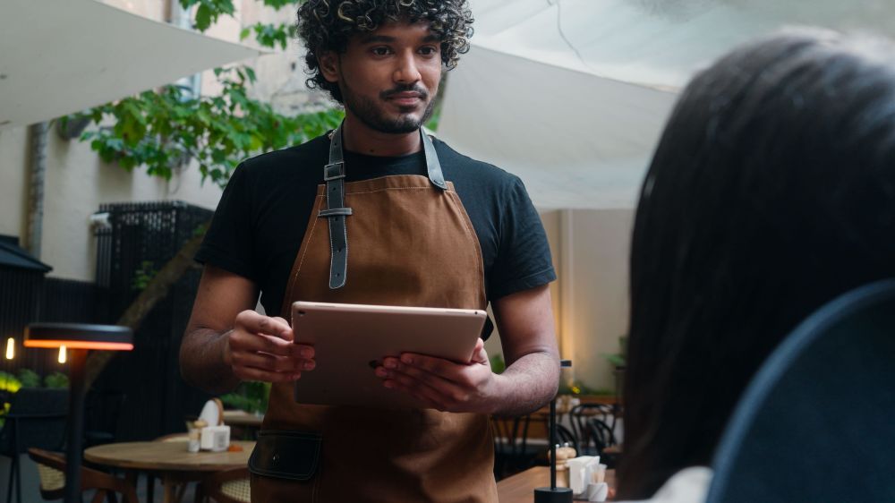 Asian man taking an order in a restaurant