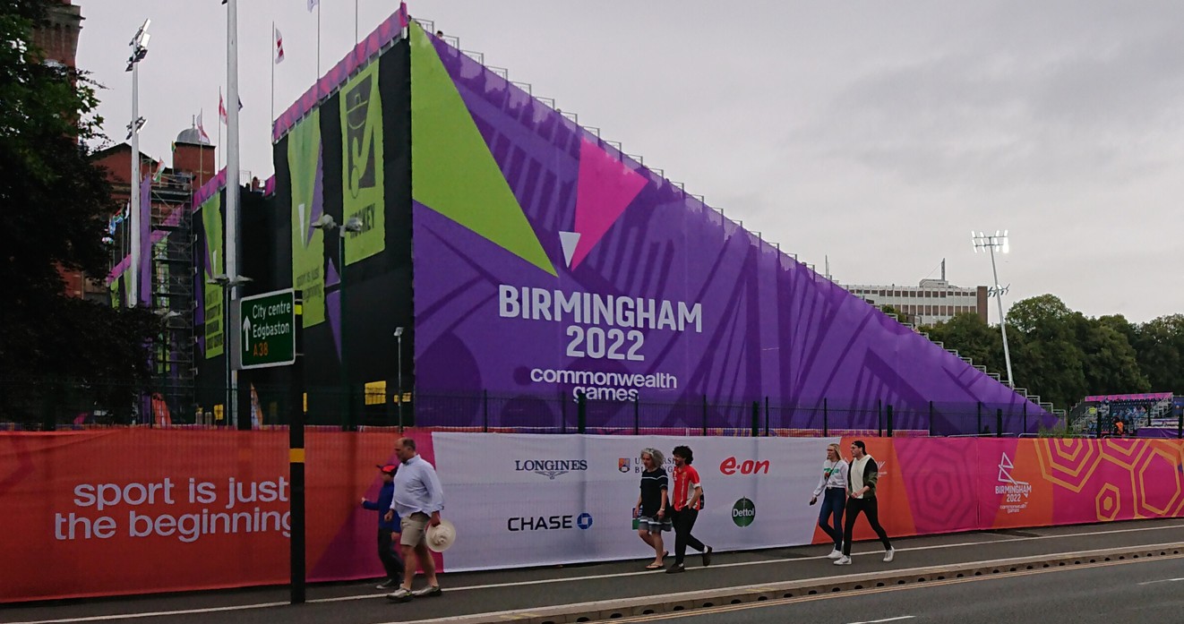 People walking past a sign to promote the Commonwealth Games in Birmingham during 2022.