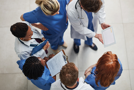 A photograph of a group of hospital staff talking to each other.