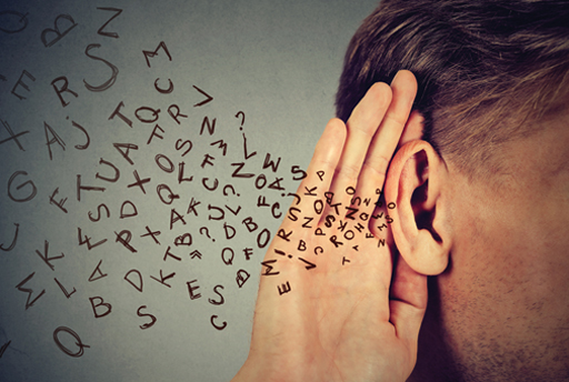 A photograph of a person cupping their ear, and letters surrounding their ear.