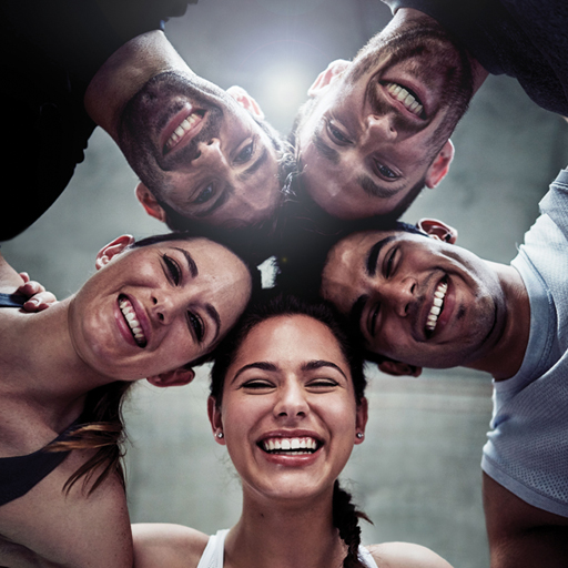 A photograph of five people with their heads together.