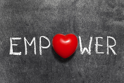 Image of the word empower written on a chalkboard, with the ‘o’ replaced with an image of a heart.