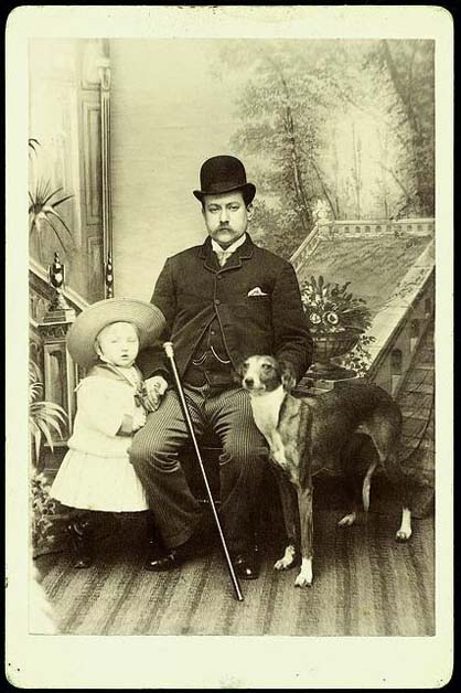 A photograph of a man, child and dog