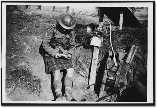 A Scottish soldier reading a letter while on gas sentry duty near the trenches