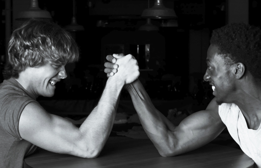 This image, depicting strength, shows two young men arm wrestling.