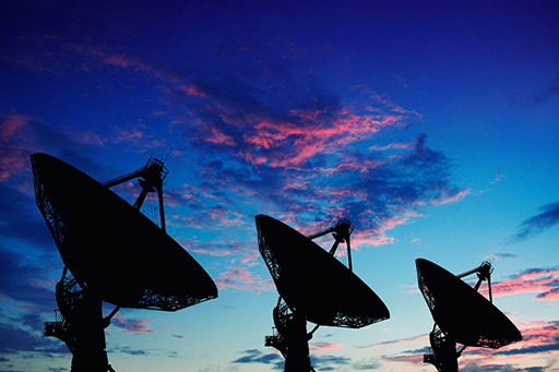 An image of three large satellite dishes.