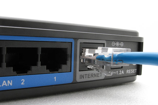The back of a wireless router with a cable going into the port labelled 'INTERNET.