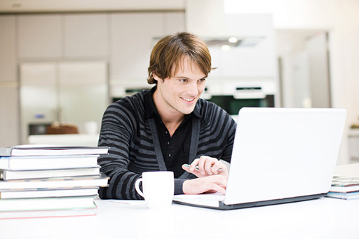A photograph of a man using a laptop.