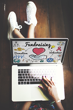 Photo of a woman looking at a page about fundraising on her laptop.