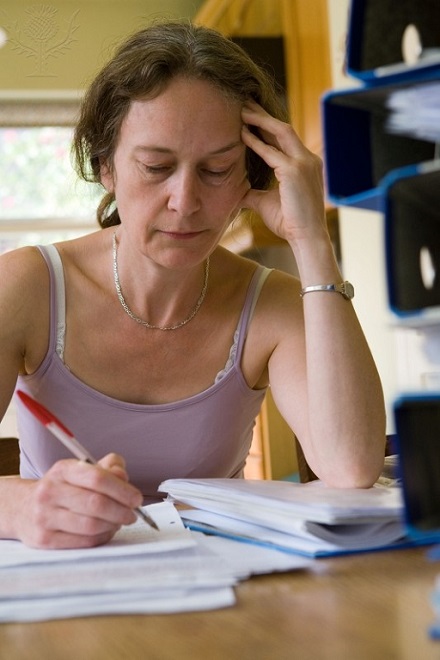 Image of woman sitting at desk with pen and paperwork