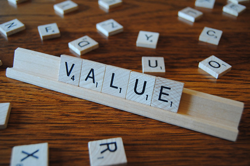 Scrabble letter tiles arranged on a rack to spell the word ‘value’.