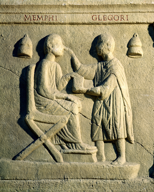Stone-carved relief of an eye doctor examining the eyes of a patient.