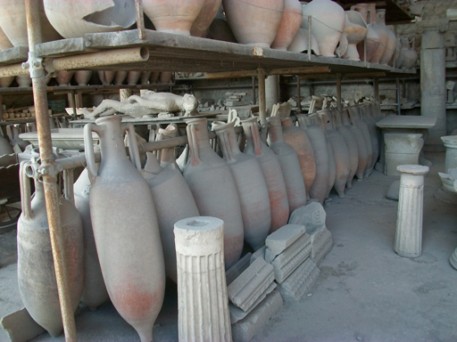 A large number of amphorae from Pompeii, stacked in a storage area.