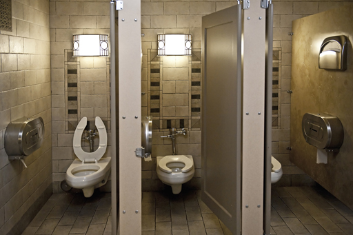 Modern-day toilets, looking into three cubicles.