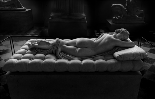 Statue of Hermaphroditos shown sleeping nude on a mattress, in a twisted pose.
