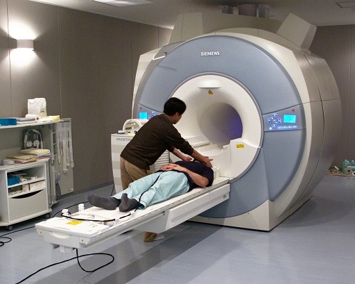 A photograph shows a person about to be scanned by an fMRI machine.