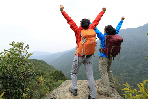 This photograph shows two people celebrating having climbed a mountain.