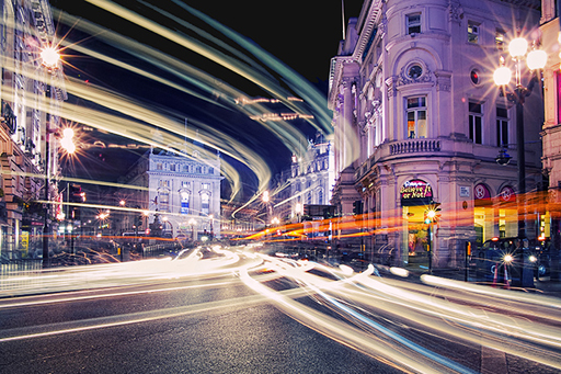 A blurred-effect photograph of Piccadilly Circus, London.