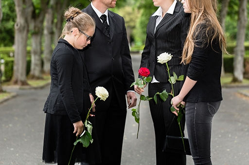 A photo of four people dressed in black mourning.