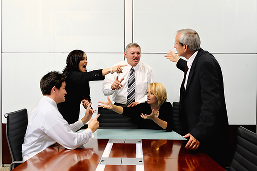 This image shows five business people around a table arguing with each other.