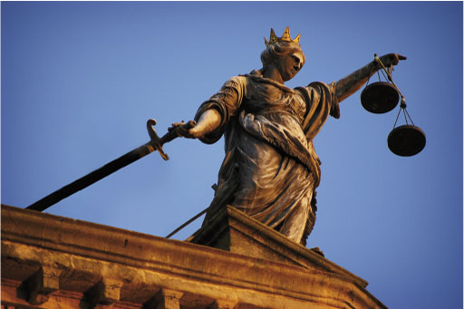 A picture of a statue with the symbols of justice, scales and a sword.