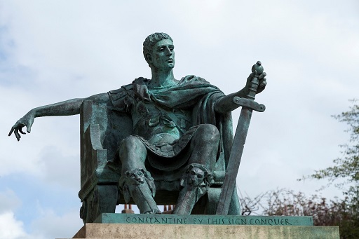 A statue of Roman Emperor Constantine. He is seated and holding a sword.