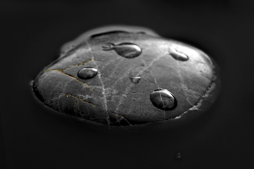 This is an image of a stone with water droplets on top.