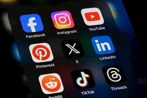 Grid of social media app icons on a smartphone screen, including Facebook, Instagram, YouTube, Pinterest, X, LinkedIn, Reddit, TikTok and Threads.