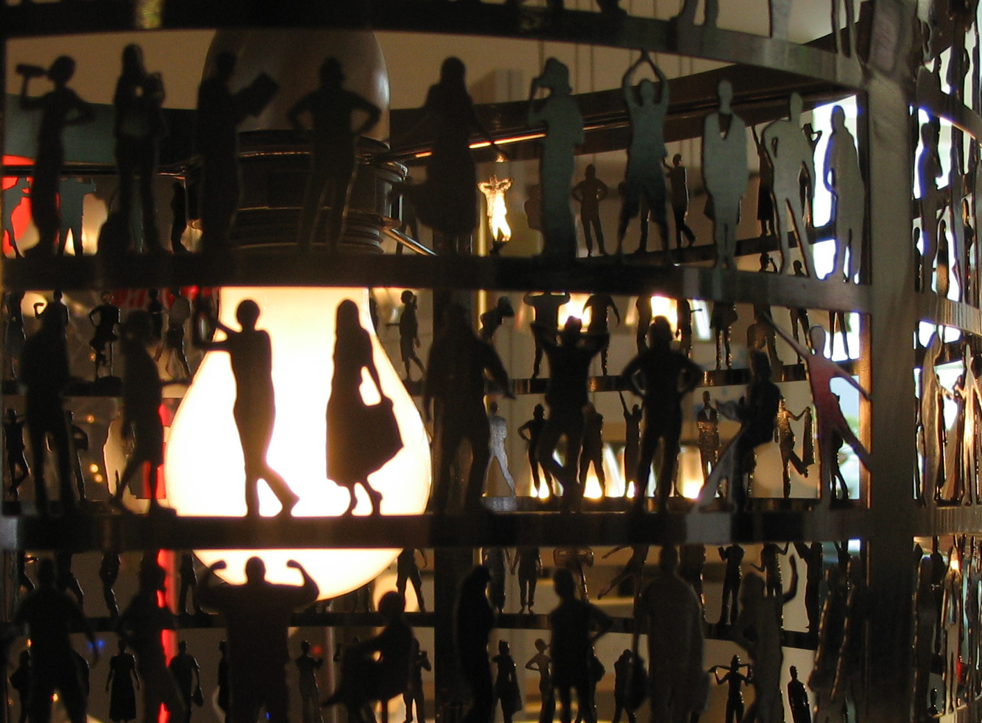 Lamp with silhouettes of people doing different activities all around it