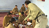 A teacher moving around his class encouraging group work activity