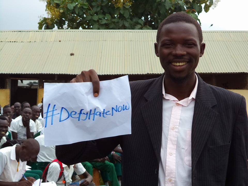 Student at high school in South Sudan with #defyhatenow message