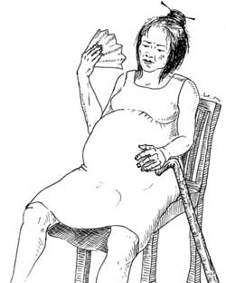 A pregnant woman is resting on a chair and trying to cool herself down with a fan.