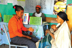 A health worker talks to a mother about immunization and family planning at her postnatal checkup.