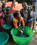 Children queue to wash their bowls.