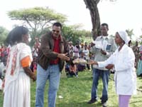 A volunteer health worker is given a reward during a ceremony attended by the community.