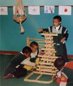 Four children play together with building blocks.