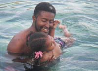 A father teaching his daughter to swim.