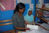 A woman and a health worker sit together in an office to talk.