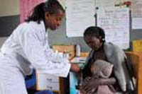A health worker is relaying a health message to a woman.