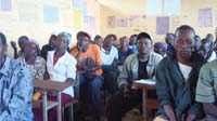 Members of the community gather in a classroom to discuss health issues.