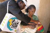 A mother holds her baby whilst they are being given polio prevention medication.
