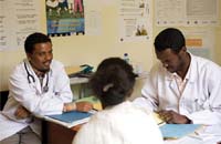 A group of health workers discuss their work in a classroom setting.