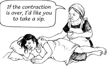 A woman in labour is lying on her side. A health worker offers her some fluids to drink between the contractions.