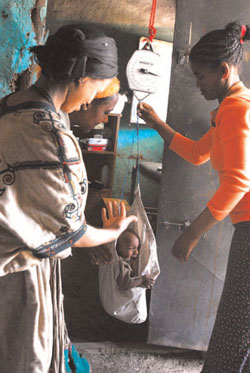 Weighing a child using a harness and spring balance