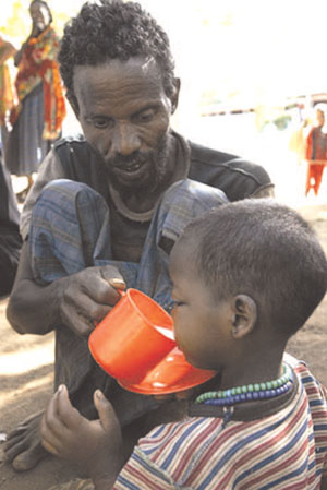 Severely malnourished child drinking therapeutic milk