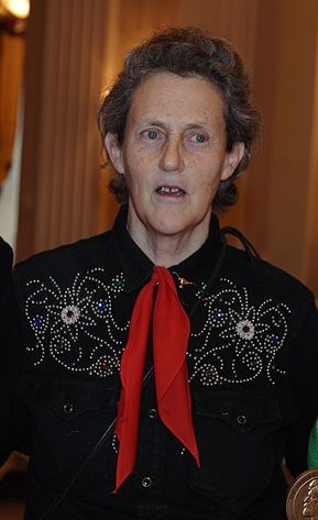 Photographie de Temple Grandin, une femme d'âge moyen aux cheveux gris courts. Elle porte une de ses douces chemises de cow-boy en coton