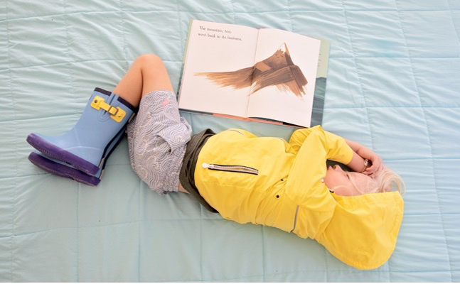 (A small child sleeping with a children’s book open by his side)