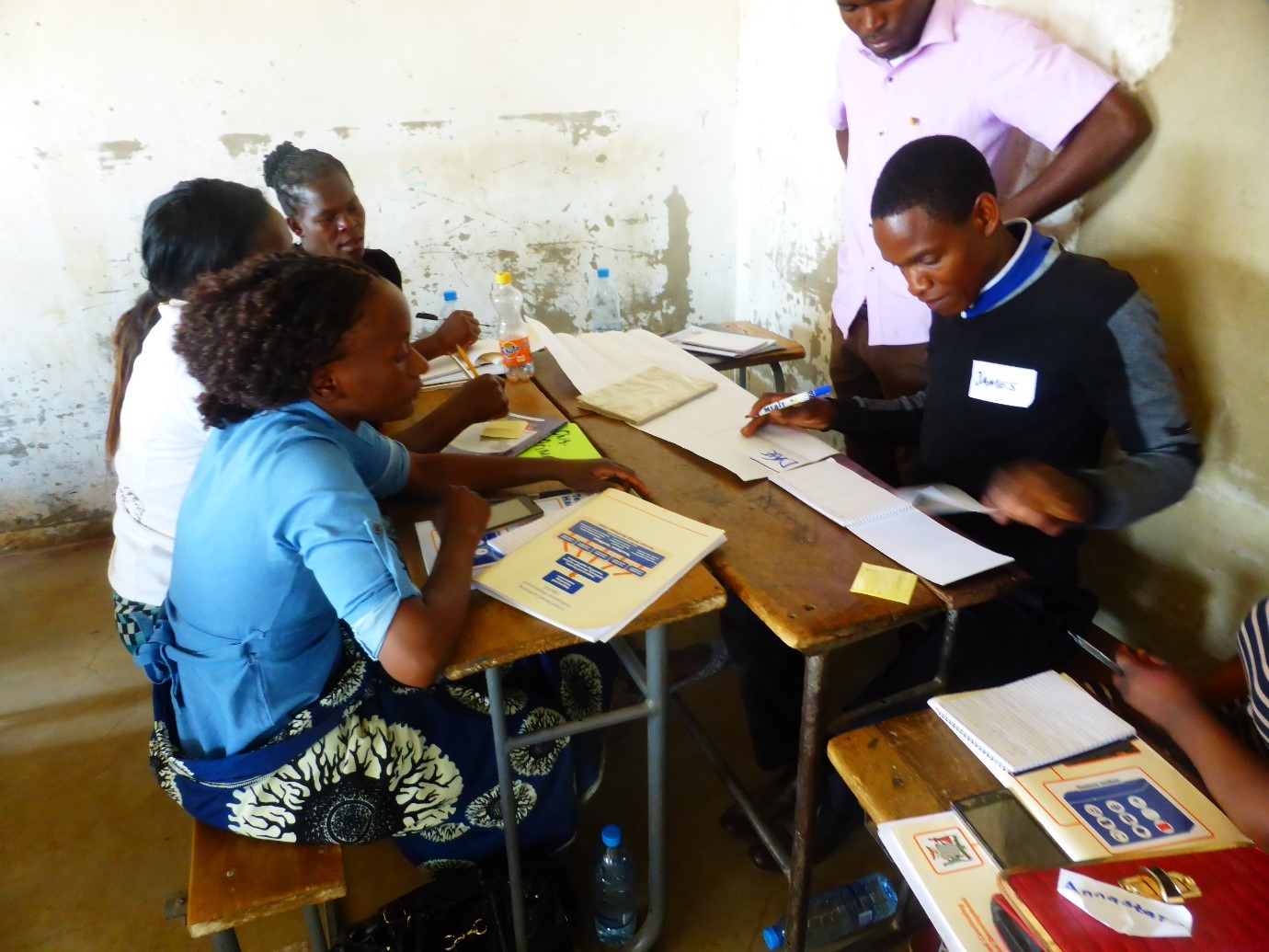 Groupe de cinq enseignant.e.s en Zambie travaillant  à la préparation de leçons