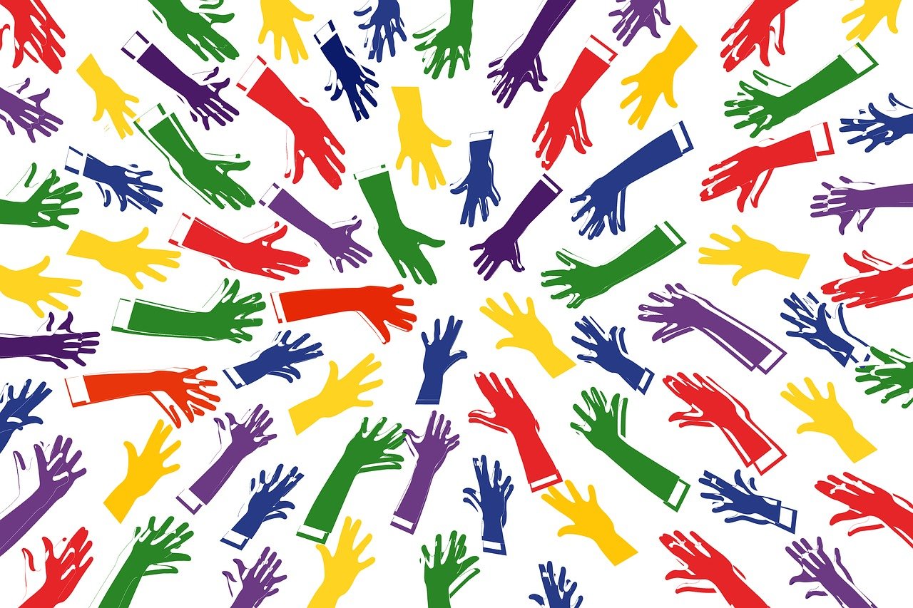 Image de mains de toutes les couleurs (rouges, vertes, bleues, jaunes, etc) tendues vers le centre de l'illustration